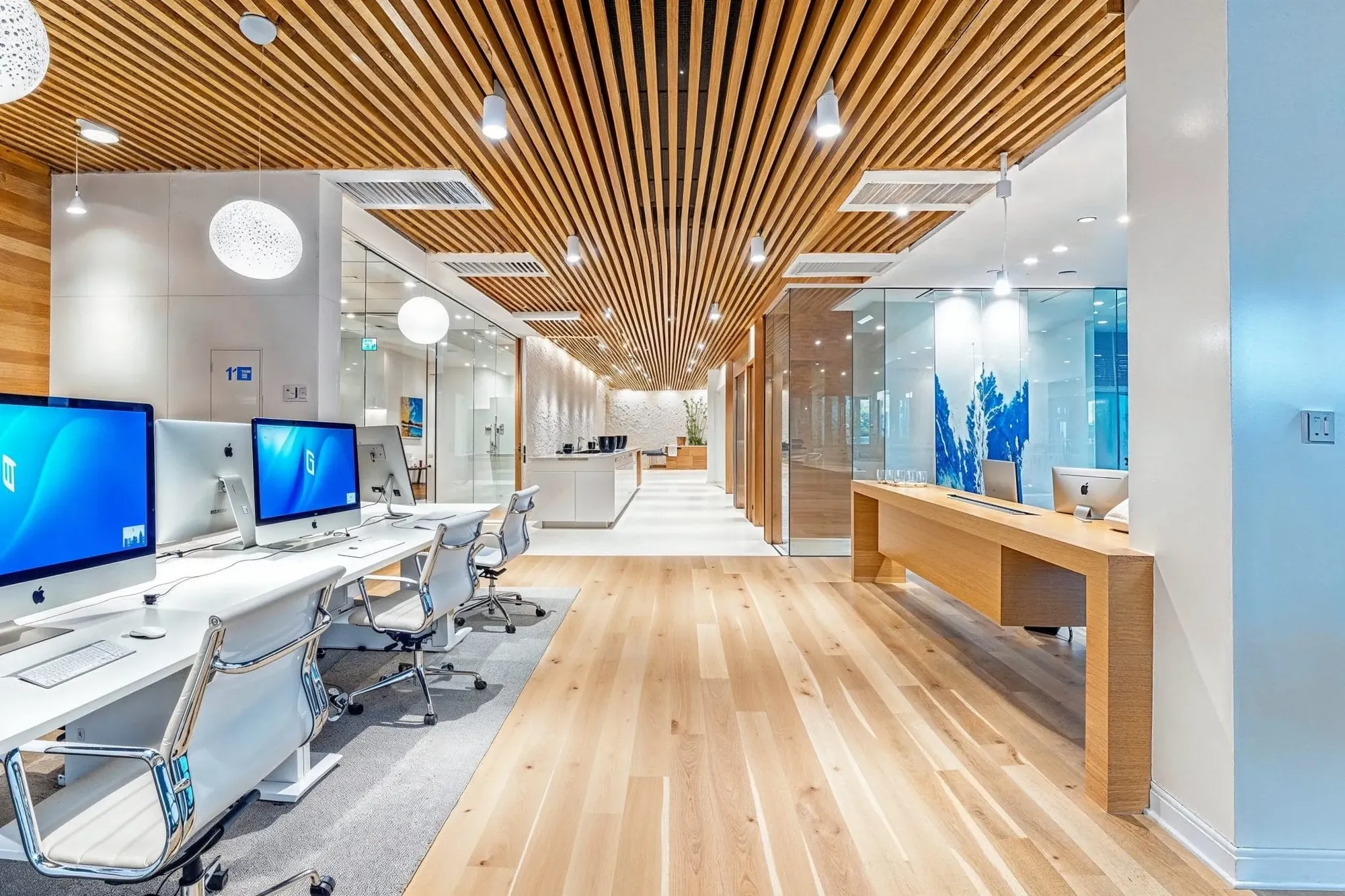 Office corridor under a wood-slat ceiling with glass-walled rooms